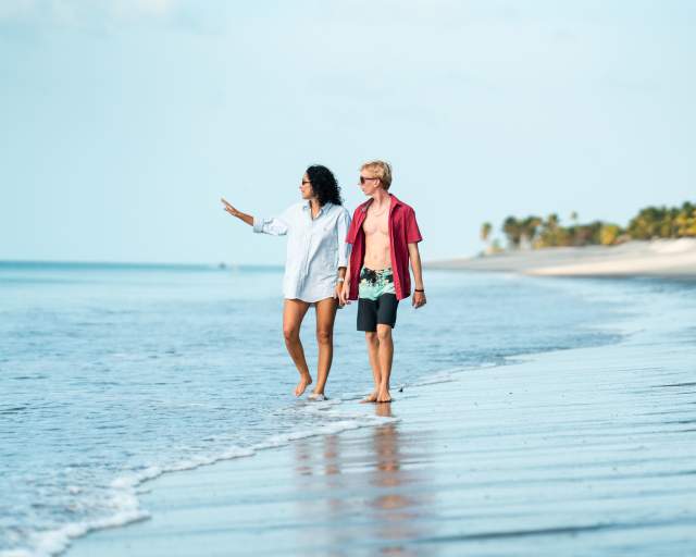 Friends leisurely walk along the sandy beach of Buenaventura