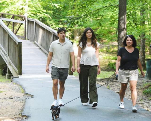 A family hiking with their dog in Creekside Park in Archdale, NC