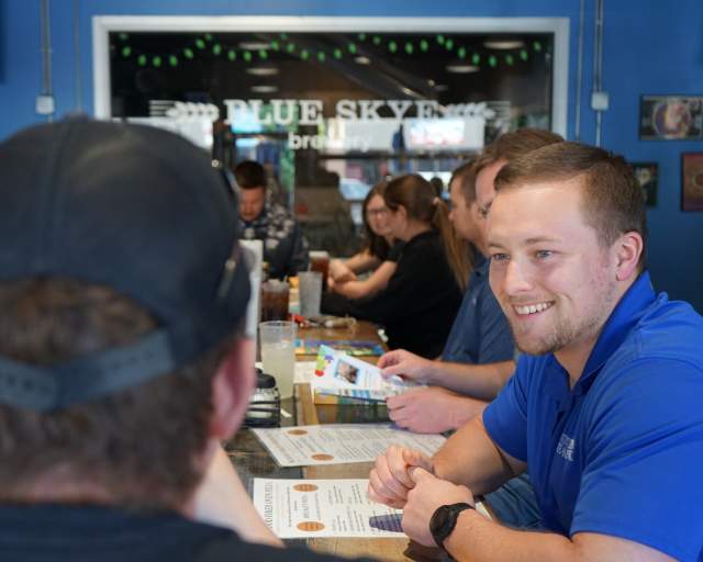 A guy smiling in a group of people at Salina Young Professionals Lunch Club in Salina, Kansas