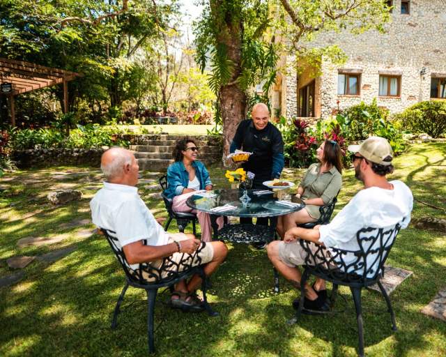 Turistas desfrutando de uma refeição ao ar livre nos jardins de um hotel boutique em El Valle de Antón, Panamá.