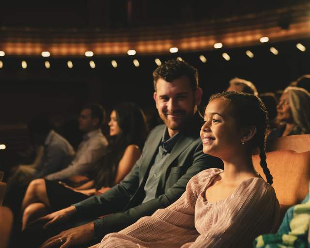 A father and daughter enjoy a show at Steinmetz theater
