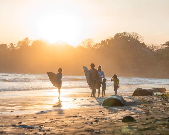 Sunrise view of surfers walking on the coast of Estero Beach at Santa Catalina