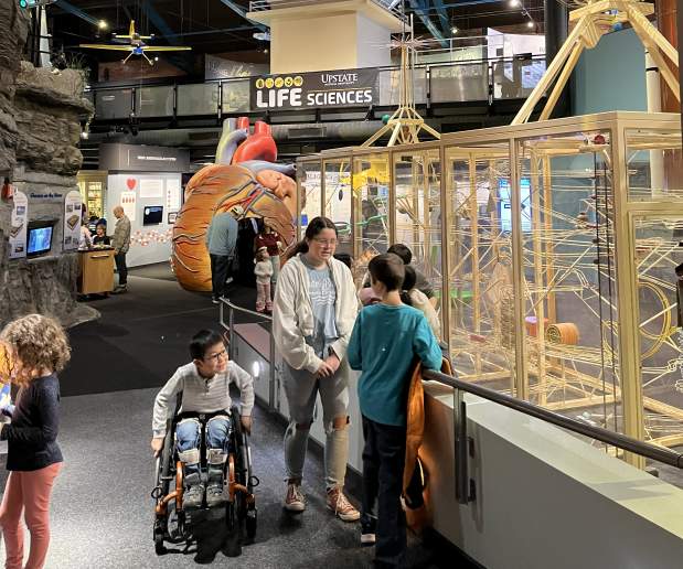 Children in front of an exhibit at the Museum of Science and Technology. One child in a wheelchair.