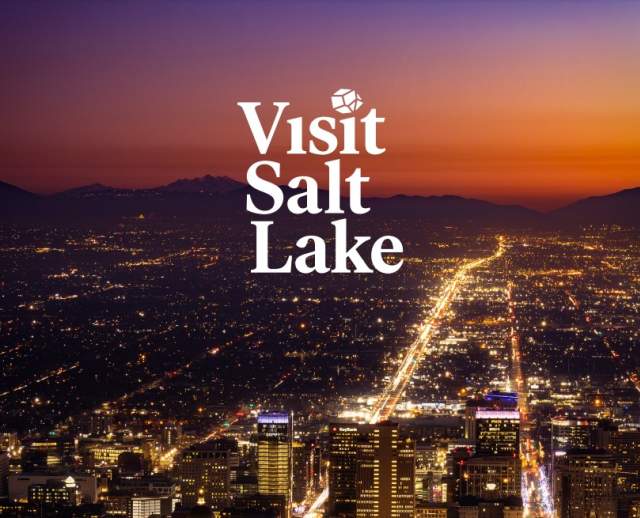 Sunset overhead view of the Salt Lake Skyline with the words Visit Salt Lake and Meeting Planner's Guide Book