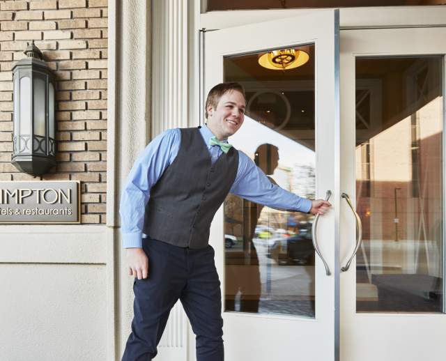 Staff opening the door to a Kimpton hotel