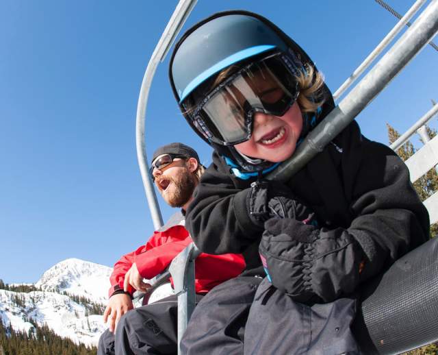 Dad and son on ski chairlift at Brighton