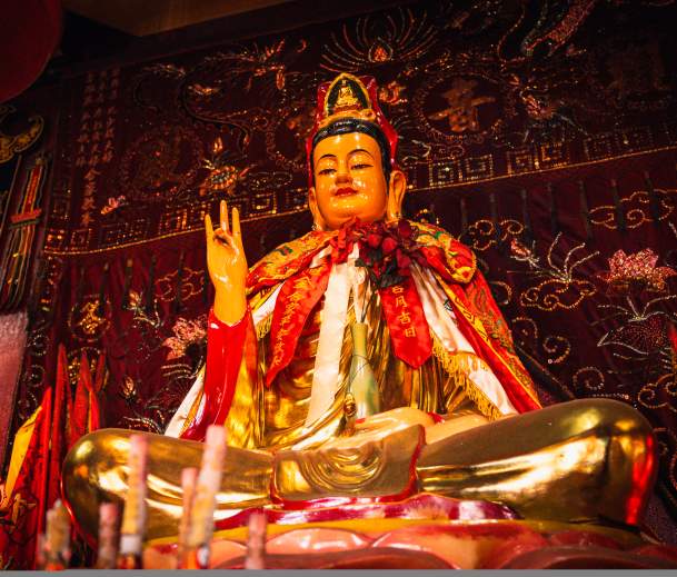 A statue of Buddha on a vibrantly decorated altar