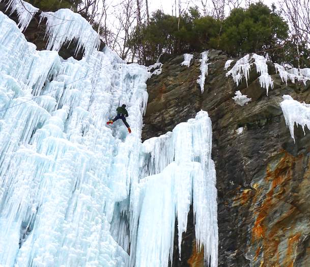 Person Ice Climbing Frozen Waterfall