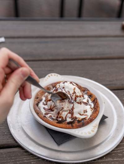 An individual chocolate chip pie with ice cream and chocolate syrup