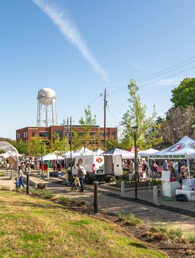 Farmers Market tents with blue sky and water tower in background