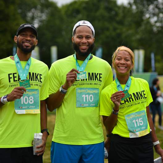 Three people smile and show off their 5k medals during the World Championships Oregon22