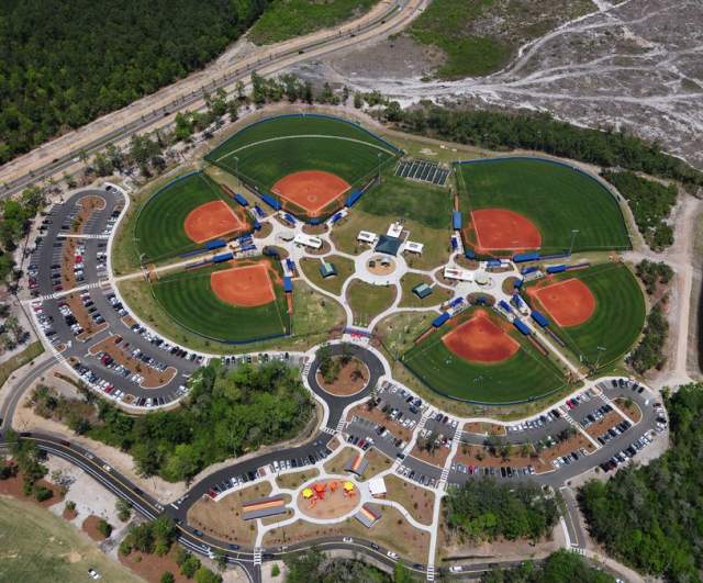 Aerial view of a North Myrtle Beach sports complex featuring multiple baseball fields, surrounding parking, playground areas, and green spaces.