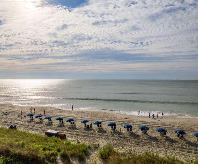 A Beach with Chairs on a sunny day with white clouds