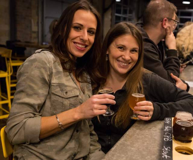 Two friends enjoying a night out at a local brewery in Greater Akron.
