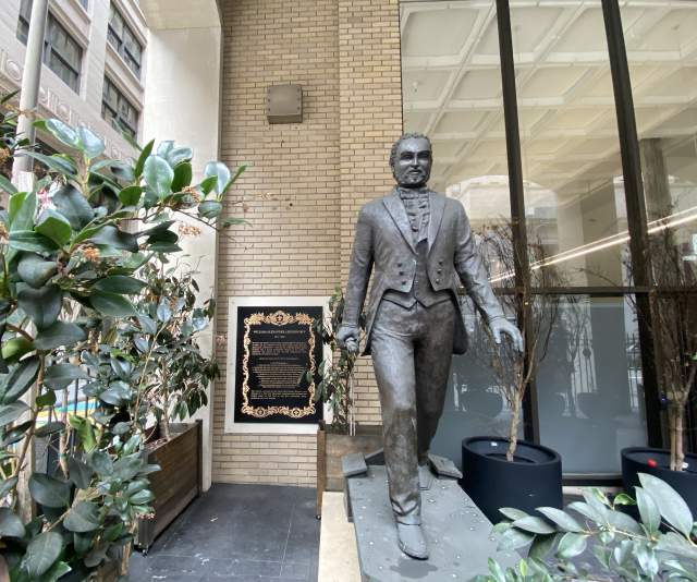 A bronze statue depicting William Alexander Leidersdorff, an African American man dressed in an 1800s suit, striding toward the viewer