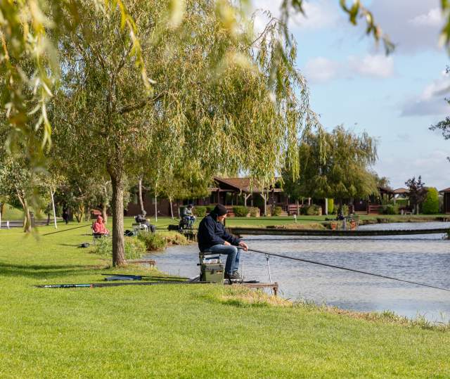 A man sat by a lake fishing
