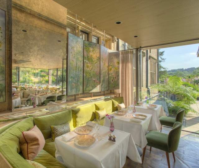 Interior tables at Gravetye Manor restaurant, with patio doors leading out to gardens
