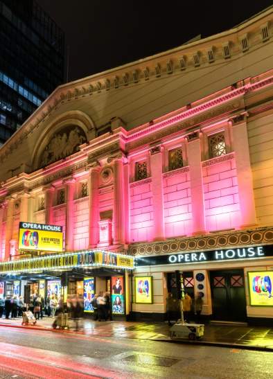 Exterior of Manchester Opera House at night with pink lighting