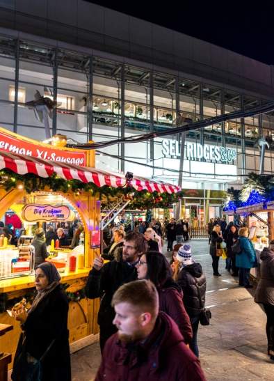 Christmas Markets at night with people in Exchange Square, Manchester