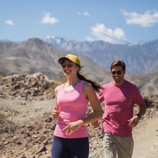 A couple wearing pink is hiking in the desert mountains