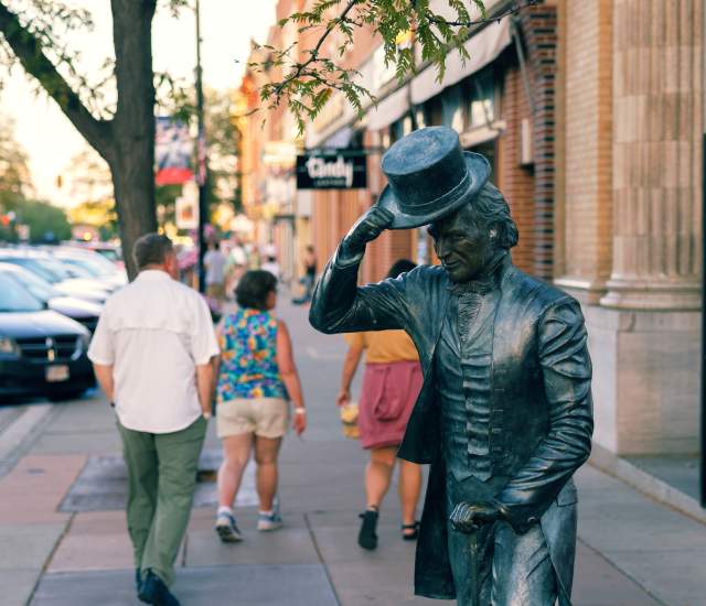 James monroe city of presidents statue in downtown rapid city with people on sidewalk behind statue