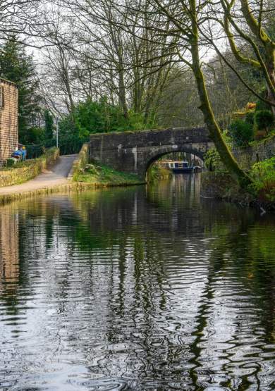 Canal with stone bridge and cottages in Oldham