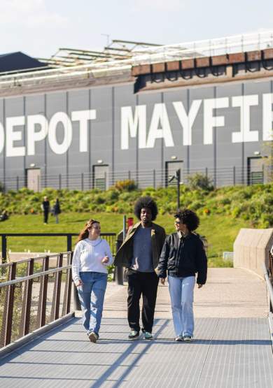 Friends walking along a bridge at Mayfield Park with Depot Mayfield sign in the background