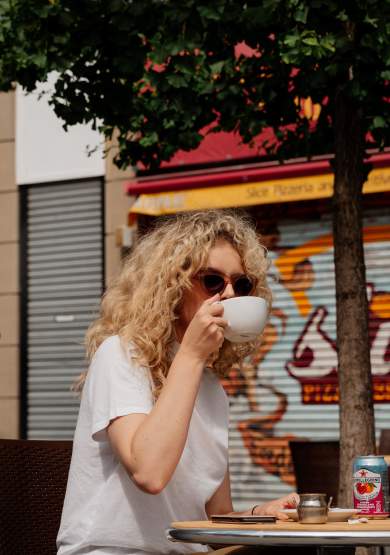 Person drinking coffee on a table in the sun in Manchester