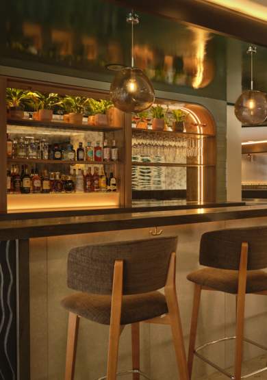 Hotel bar set up with seating and hanging lights