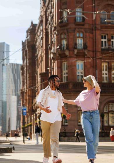 Couple walking through st peter's square in manchester
