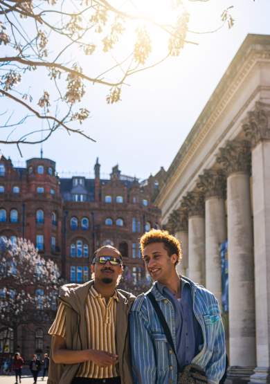 2 people outside Manchester Central Library in the sun