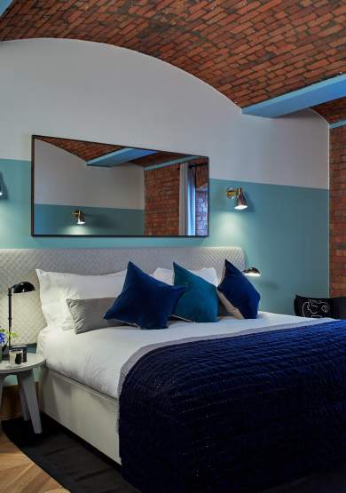 Hotel bedroom with exposed brickwork and large bed
