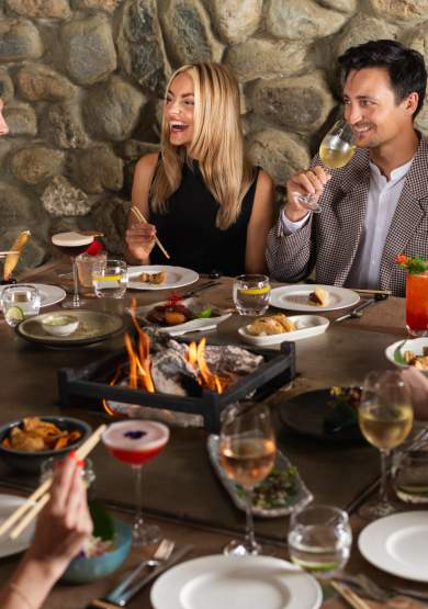 Group of people sat around table with food and drinks