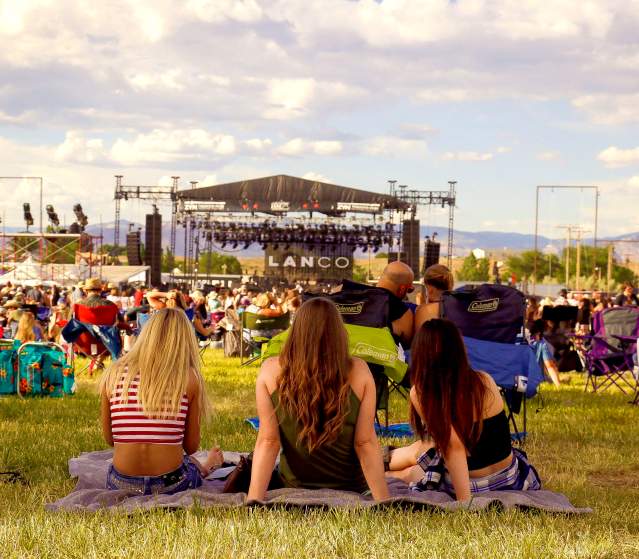 Three Women Sitting and Watching concert at Country Jam Colorado