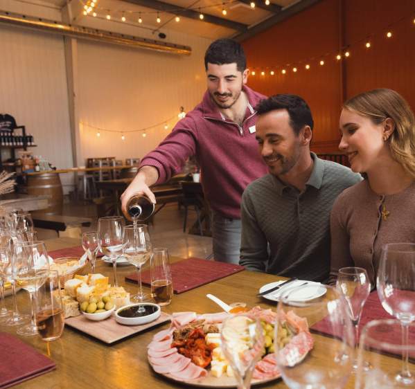 Server pouring wine for couple at a table