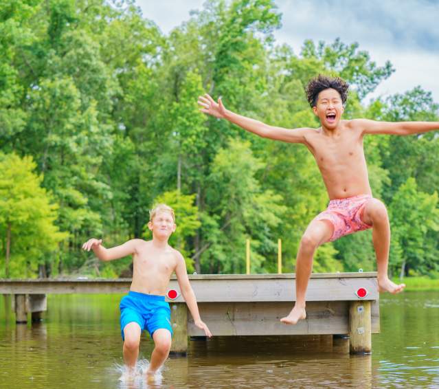 Two Boys Jumping Off a Pier at Cypress Black Bayou