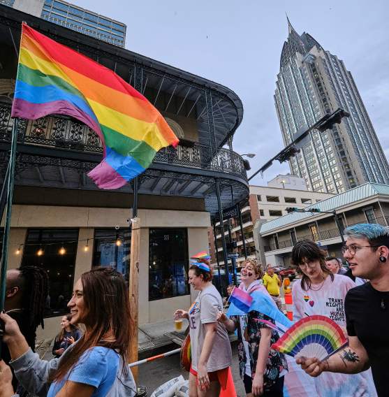 Group of people in the street with rainbow fan and a rainbow flag