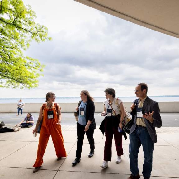 Meeting attendees walking behind Monona Terrace with Lake Monona behind them