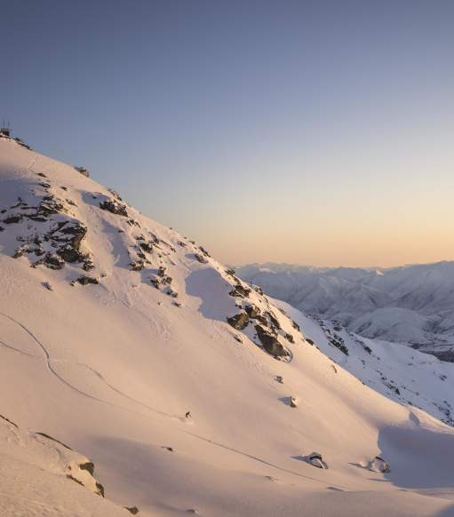 Far shot of person skiing at the Remarkables ski aera at sunrise