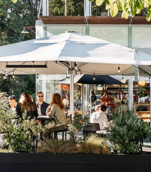 View of a people sitting in a cafe courtyard surrounded with greenery