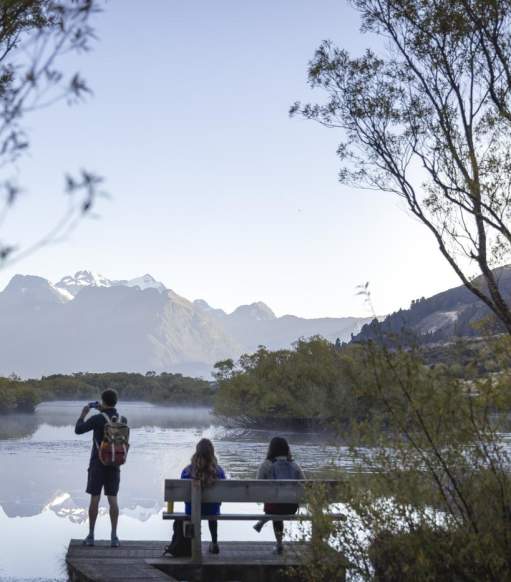 People at the Glenorchy Lagoon Walkway lookout, overlooking lake and mountains