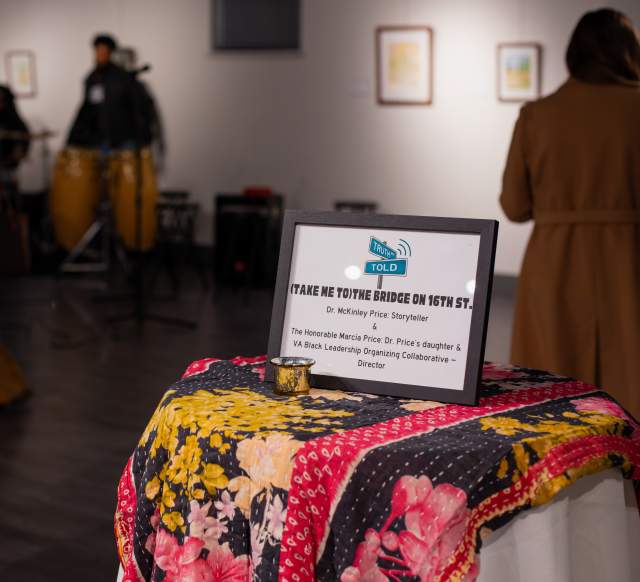 A table set in a gallery reads "take me to the the bridge on 16th street"