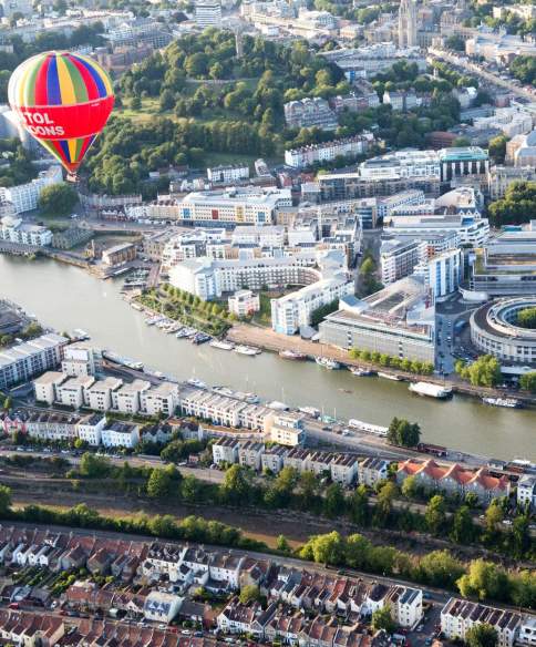 An aerial view of hot air balloons flying over Bristol Harbourside