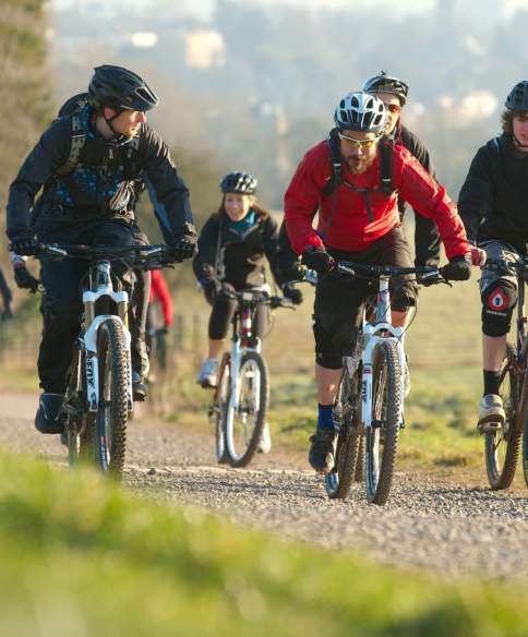 A group cycling on rented mountain bikes towards the off-road mountain biking trail at Ashton Court - credit Pedal Progression
