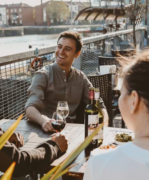 Friends drinking wine on the terrace at Harbour House