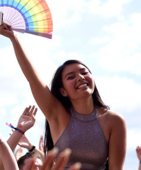 A women holding a rainbow fan  - Credit Bhagesh Sachania