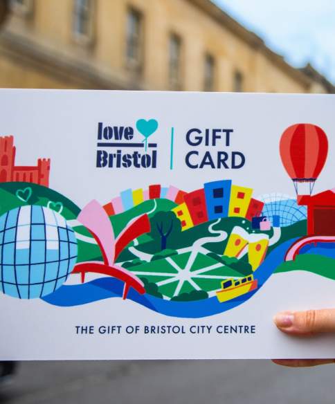 Hand holding a Love Bristol Gift Card shopping voucher in Park Street, central Bristol - credit Bristol BIDs