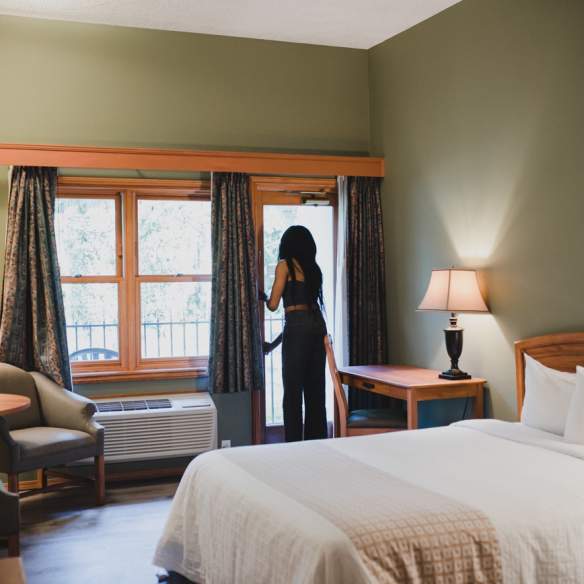 A person looking out their window in a hotel room.