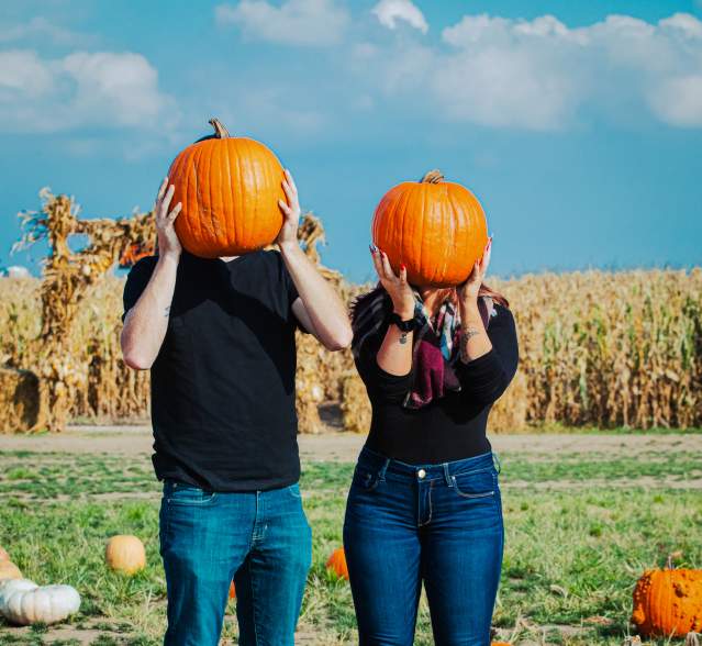 Couple holding pumpkins
