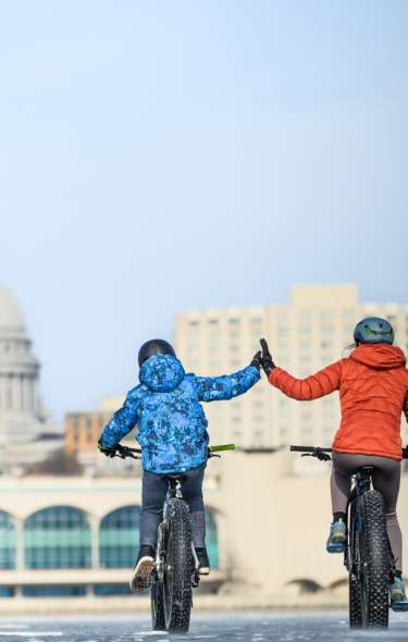 Two people bike on frozen Lake Monona